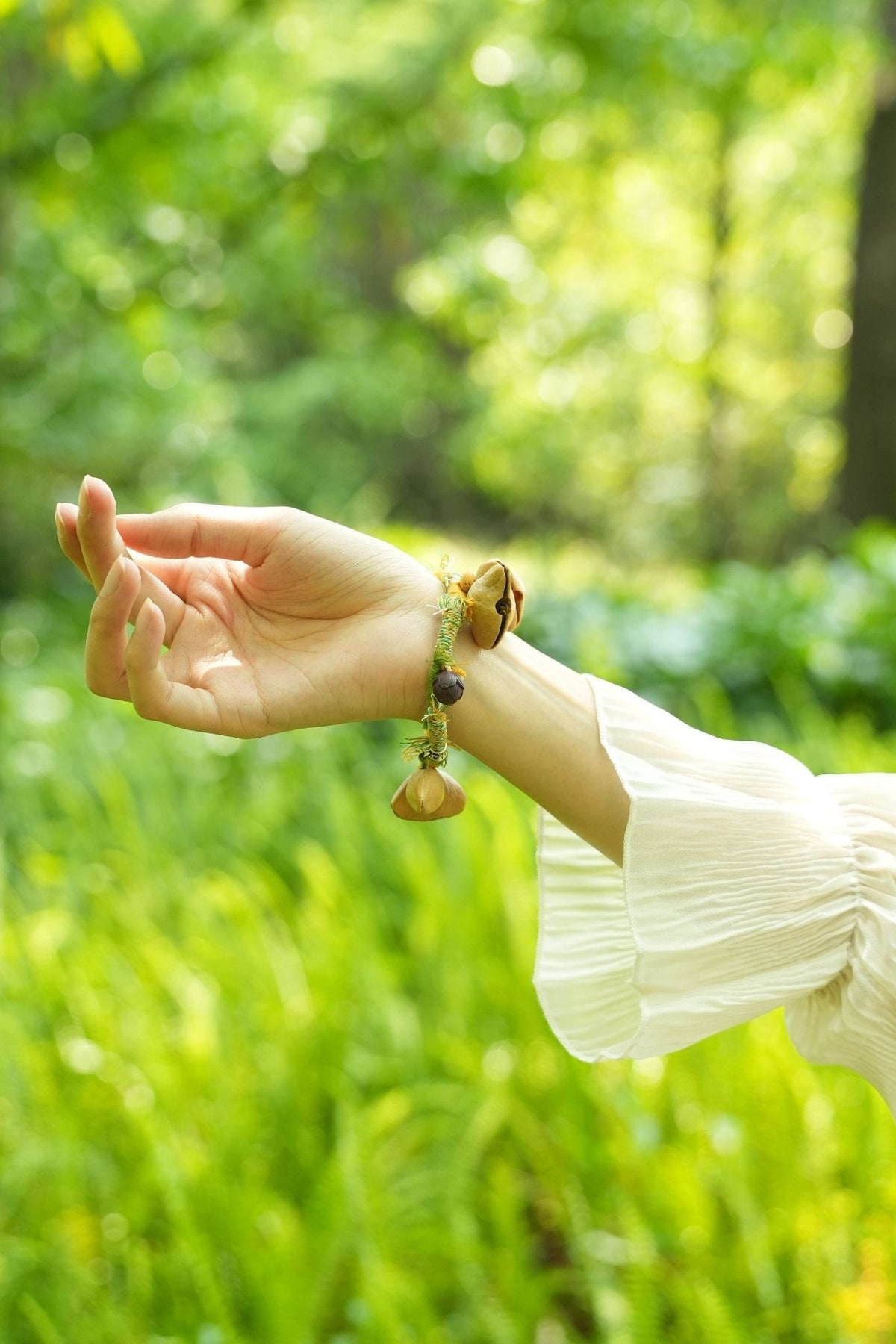 La Danseuse des Prairies - Bracelet tressé jaune et vert avec des clochettes en graines naturelles