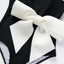 Elegante traje de baño de una pieza en blanco y negro con detalle de lazo
