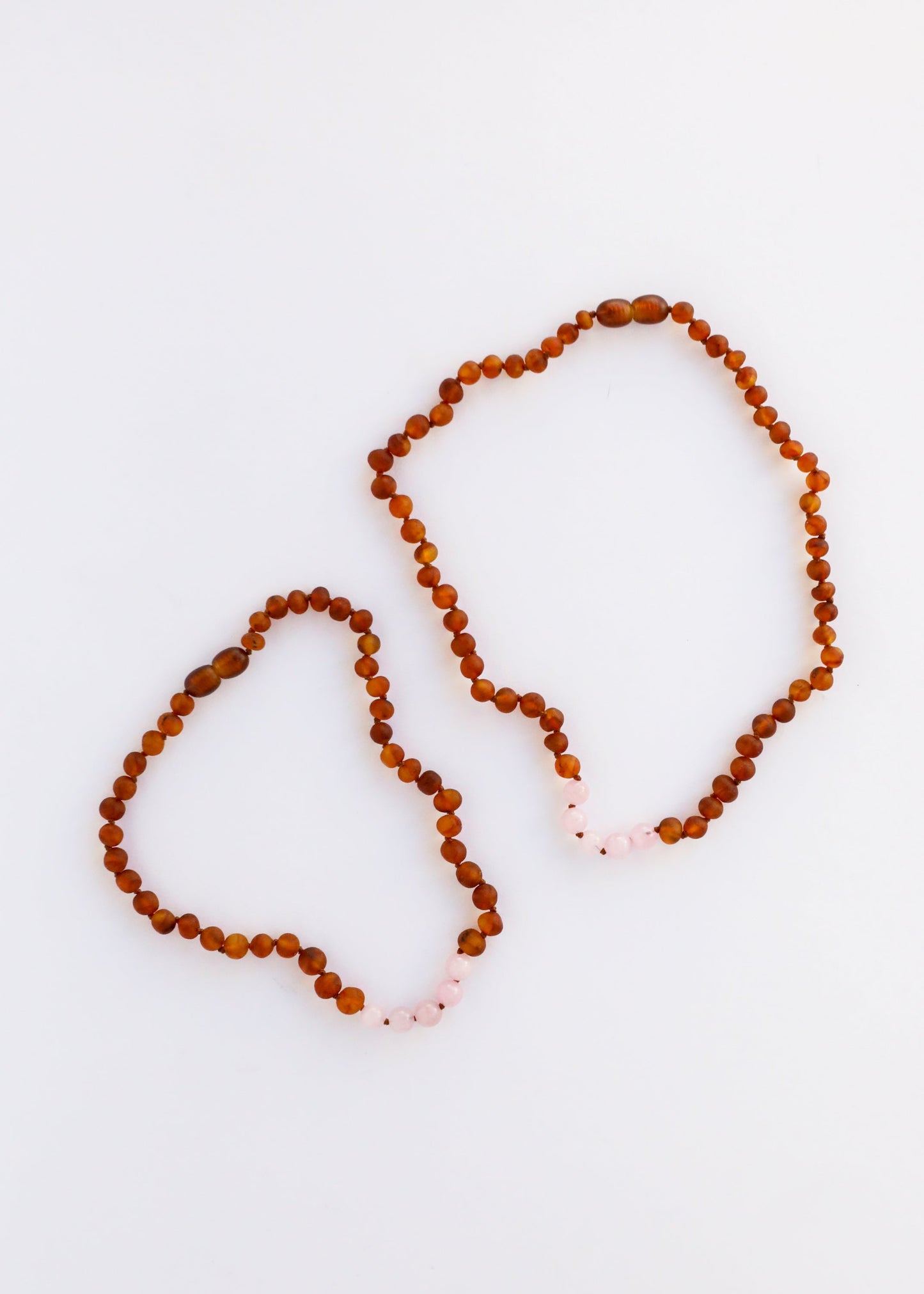 Ensemble de collier en ambre baltique cognac brut et quartz rose