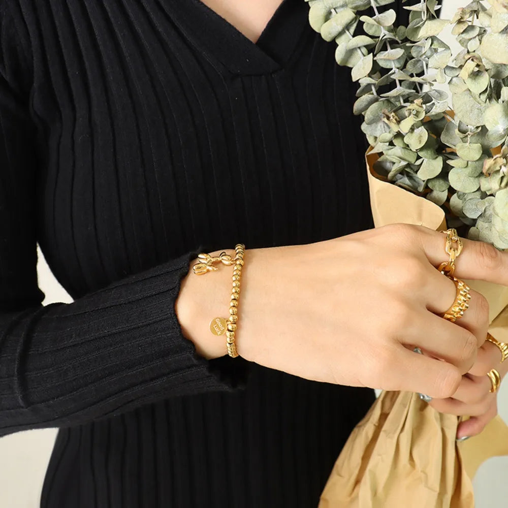 Pulsera con encanto de cachorro de acero de titanio chapado en oro de 18 quilates