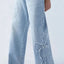 Jeans pour femmes avec broderie et ourlet effiloché en forme de papillon