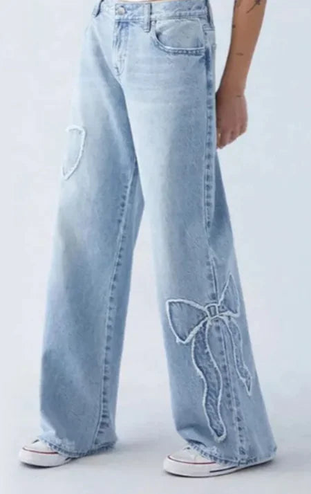 Jeans pour femmes avec broderie et ourlet effiloché en forme de papillon