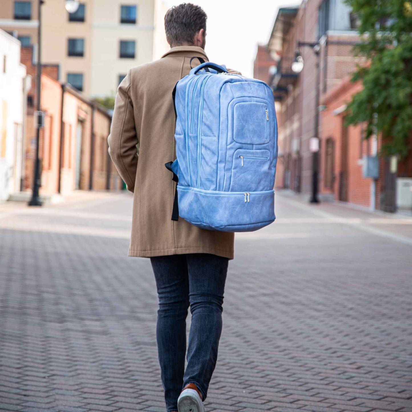 Elegante mochila de mano de cuero azul bebé para viajeros