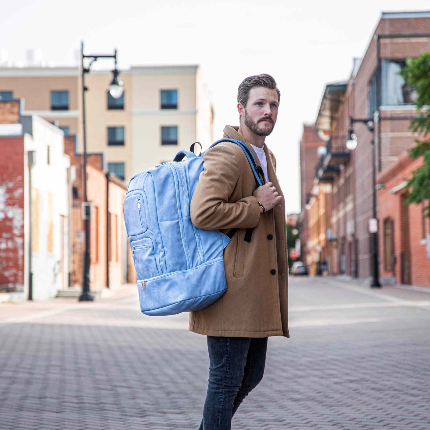 Elegante mochila de mano de cuero azul bebé para viajeros