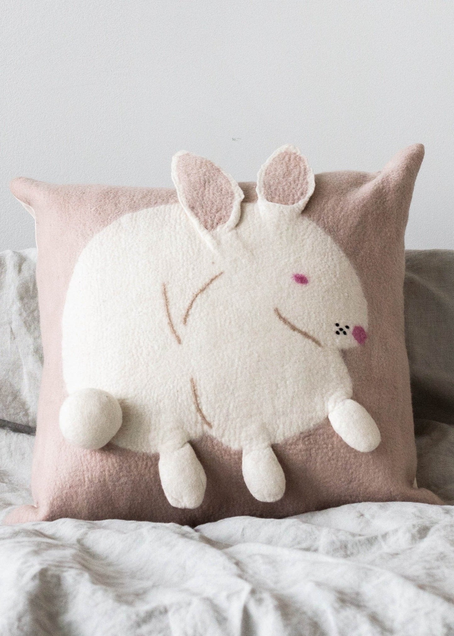Cojín de lana Blush con diseño de conejo