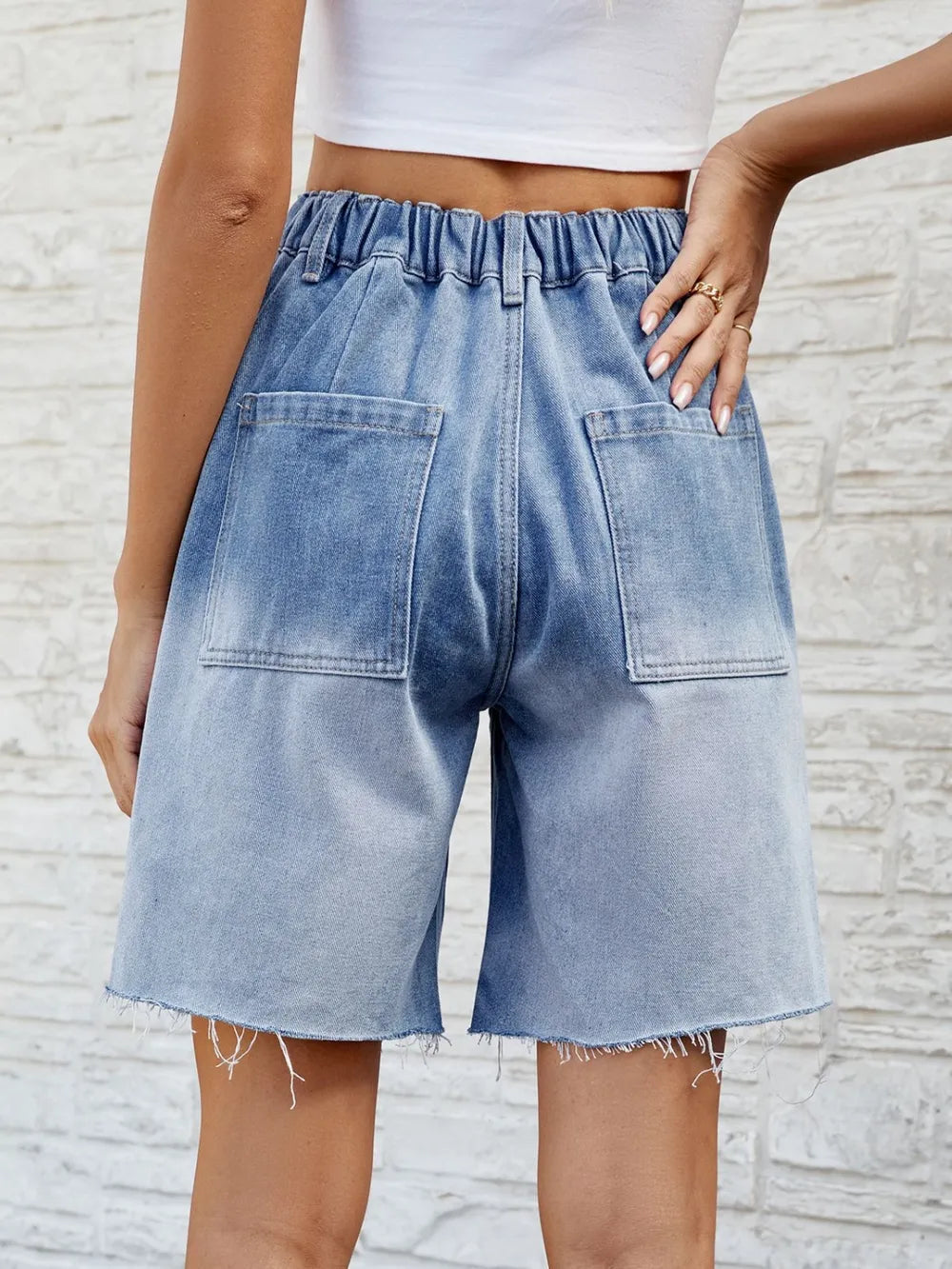 Shorts de mezclilla con dobladillo sin terminar y botones con bolsillos