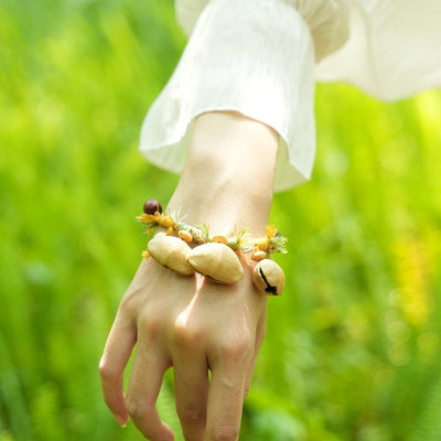 La Danseuse des Prairies - Bracelet tressé jaune et vert avec des clochettes en graines naturelles
