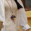 La Cloche Zen - Collier Pendentif Minimaliste en Graine et Rudraksha